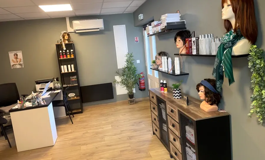 L’espace d’essayage : perruques sur têtes d’exposition, étagères de soins, bureau d’accueil