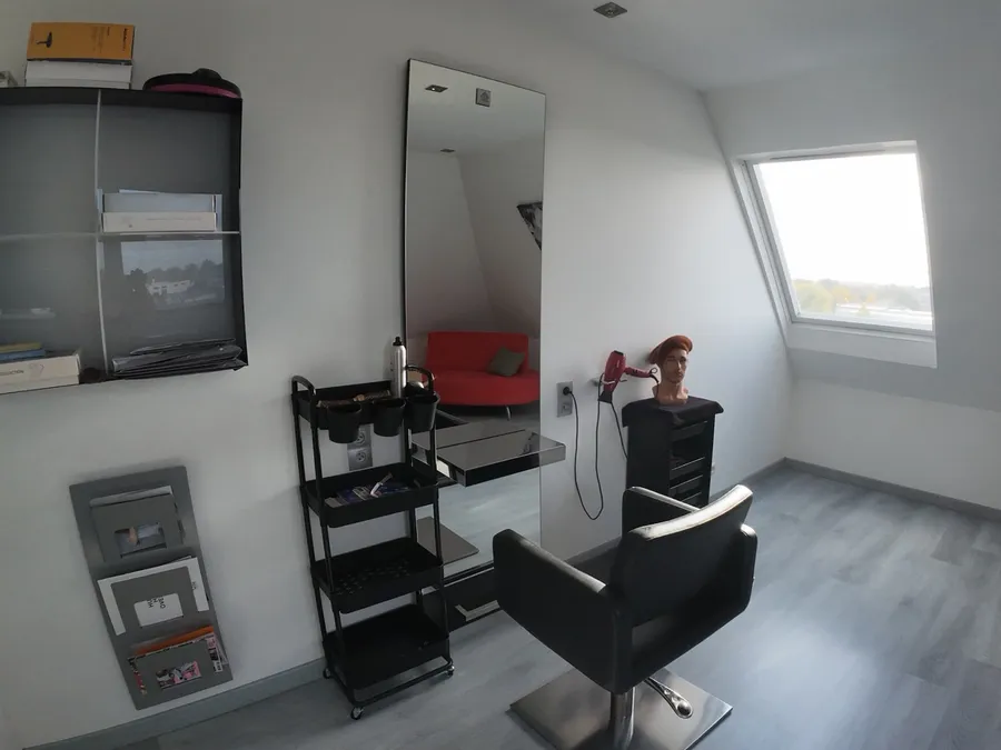 La cabine privée de l’institut de Vendenheim : un fauteuil noir face à un grand miroir, une tête de présentation, une fenêtre de toit